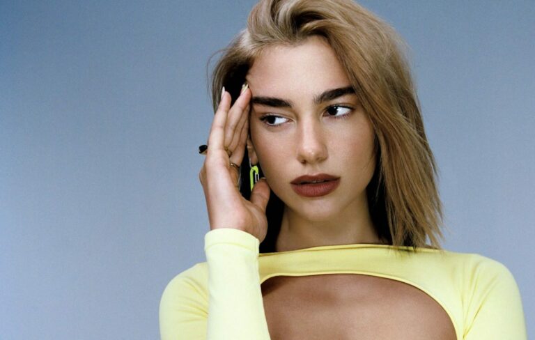 A photo of Dua Lipa with blonde hair and a yellow top