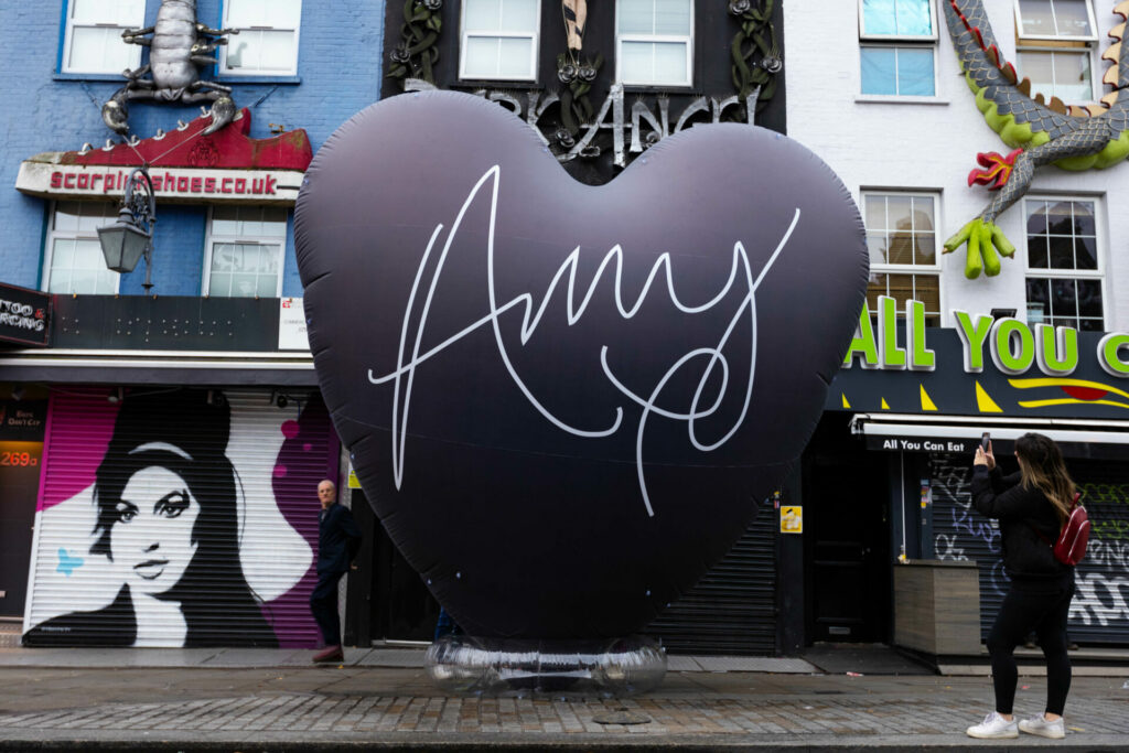 A passer-by takes a picture of a 20-foot black heart, which has been unveiled in Camden, London