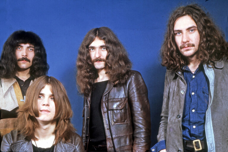 A photos of Black Sabbath from 1973 posing against a blue background