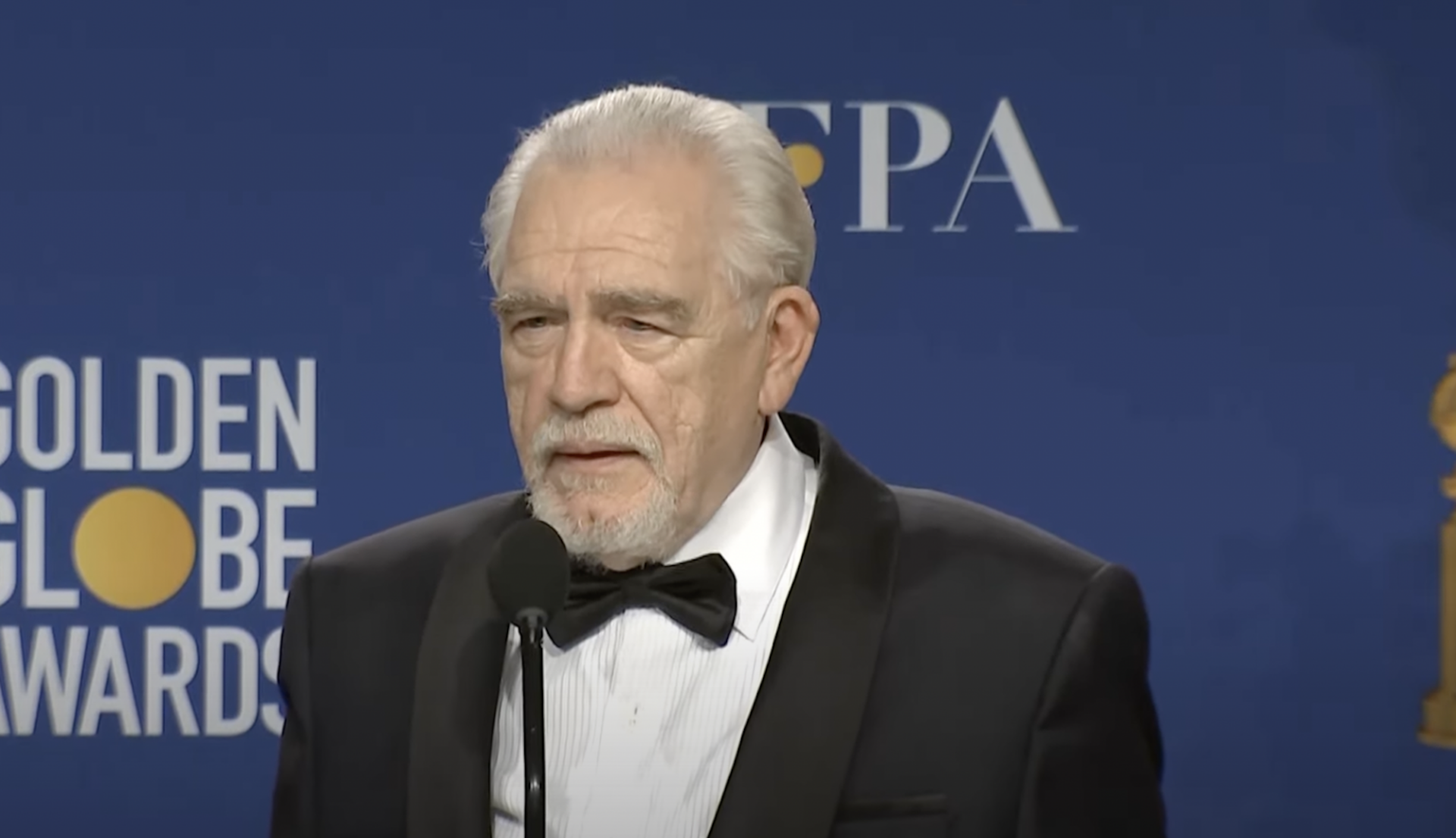 Brian Cox poses in front of a blue background at the Golden Globe Awards