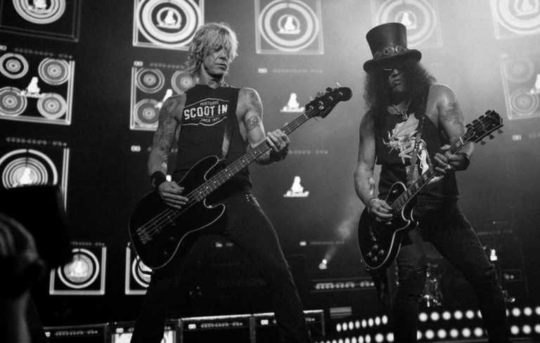 Guns N' Roses performing live in a black and white shot