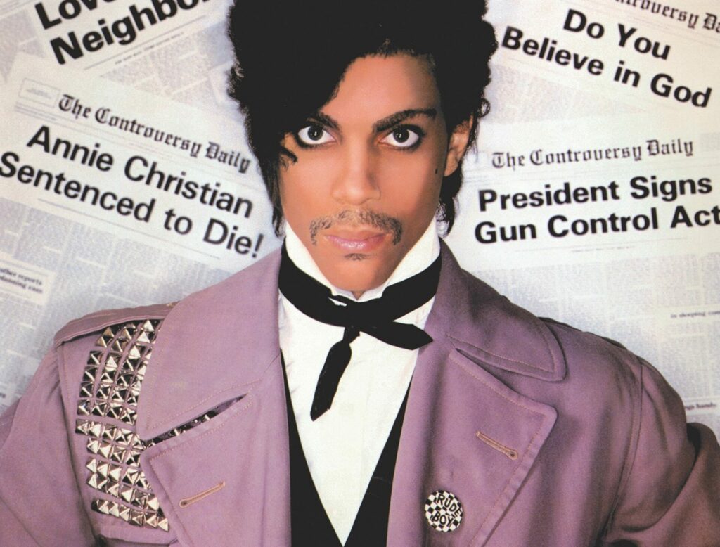 Prince poses against a newspaper backdrop