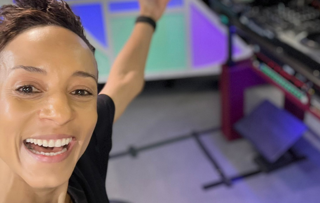 Adele Roberts takes a selfie in a radio studio, smiling at the camera