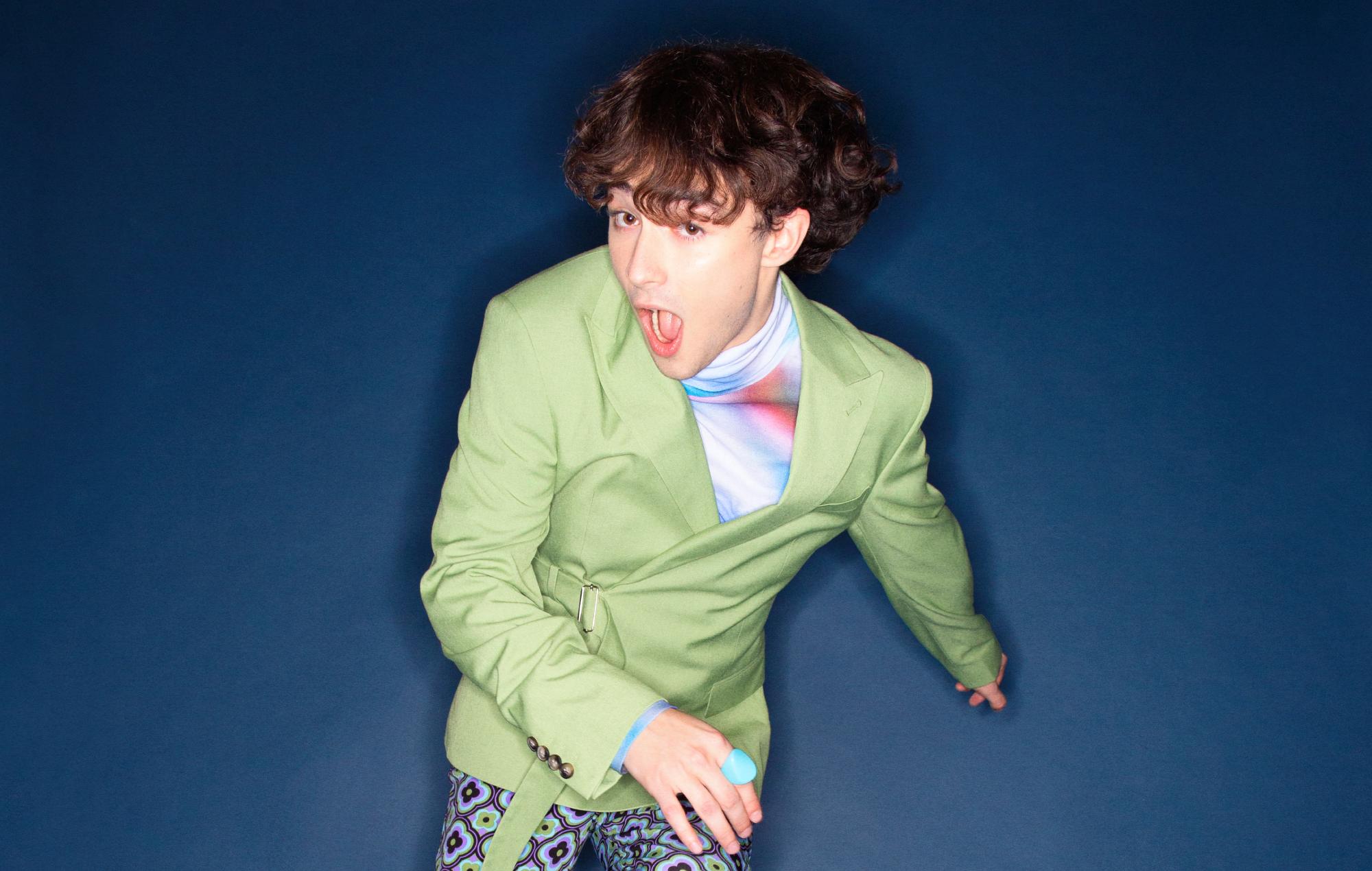 Alfie Templeman poses in a green jacket