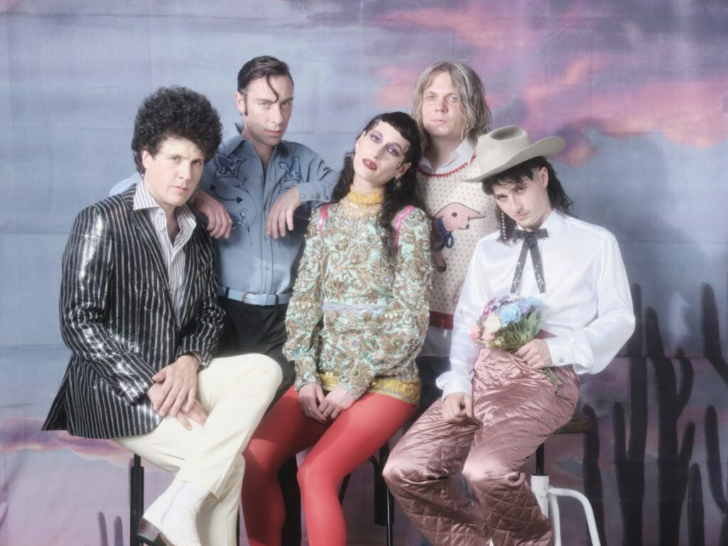 Black Lips pose for a press photo in front of a desert background
