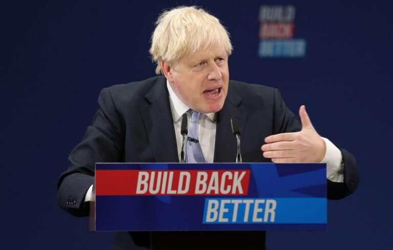 Boris Johnson stands in front of a podium that reads 'Build Back Better'.