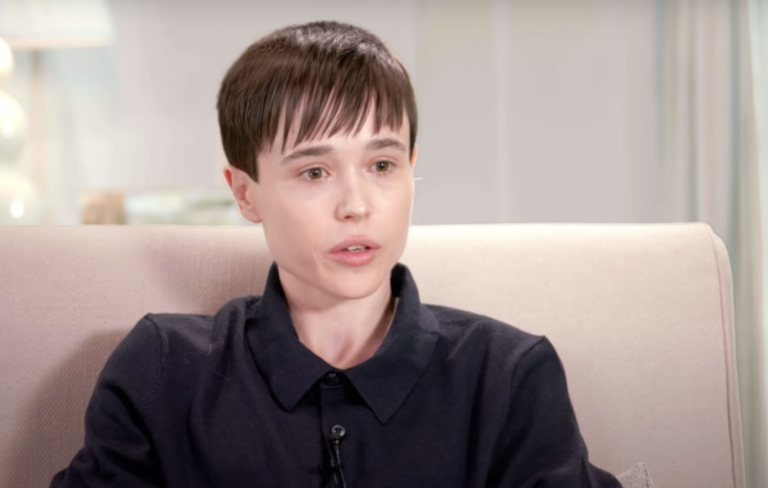 Elliot Page wears a black polo shirt on a sofa in an interview