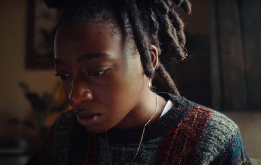 Little Simz looks down at the floor in a close up shot in 'I Love You, I Hate You’