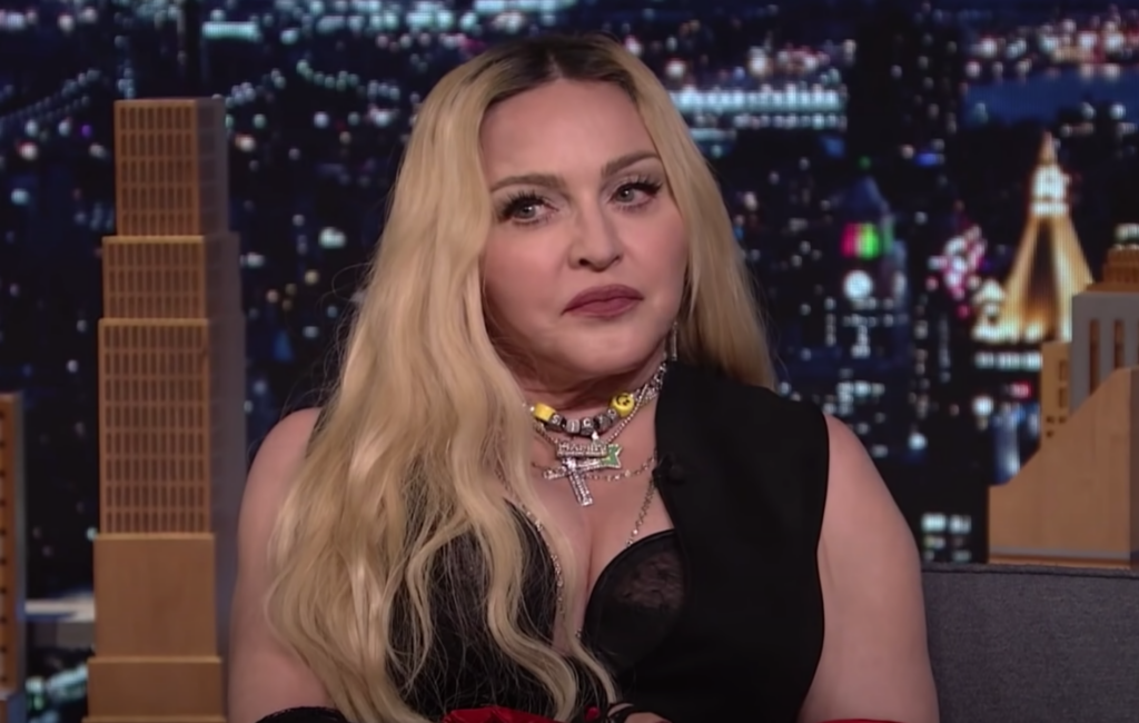 Madonna wears black and sits on a sofa at The Jimmy Fallon Show