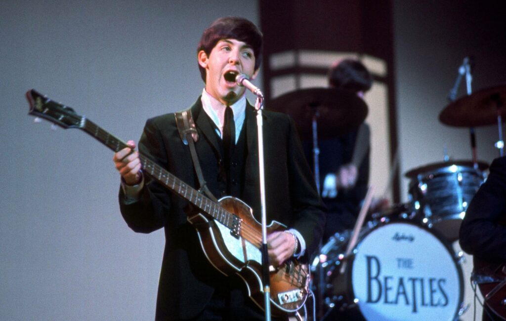 Paul McCartney performs with a guitar in The Beatles