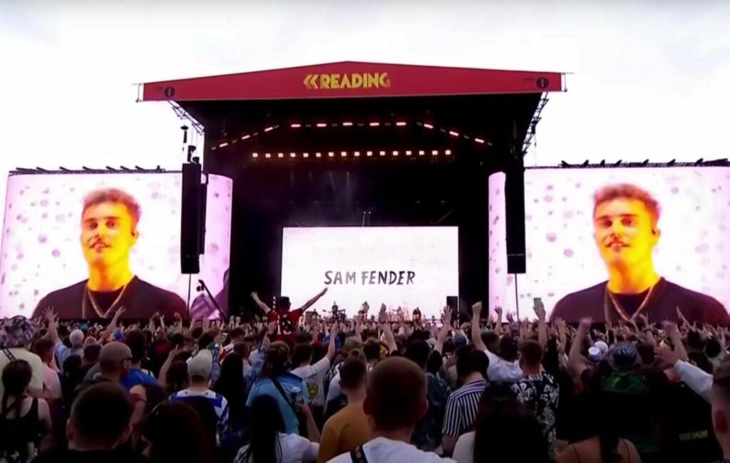 A photo from the crowd of Sam Fender performing on the main stage at Reading Festival