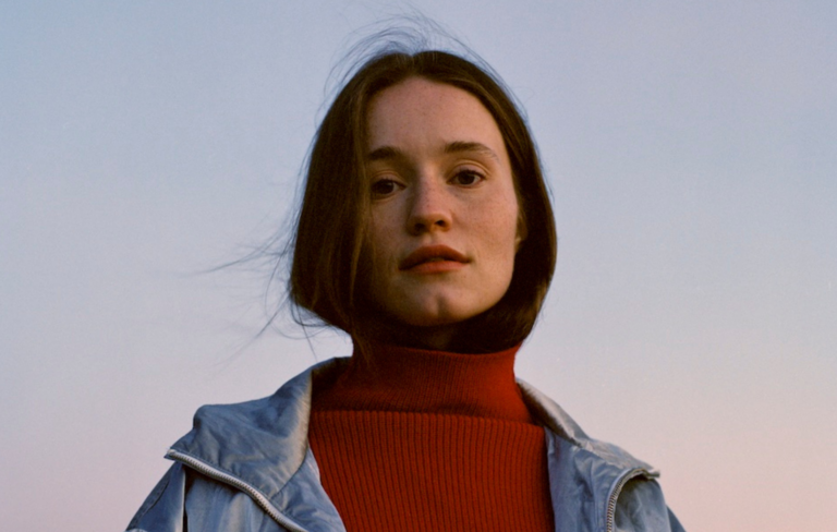 Sigrid in a red turtle neck and denim jacket