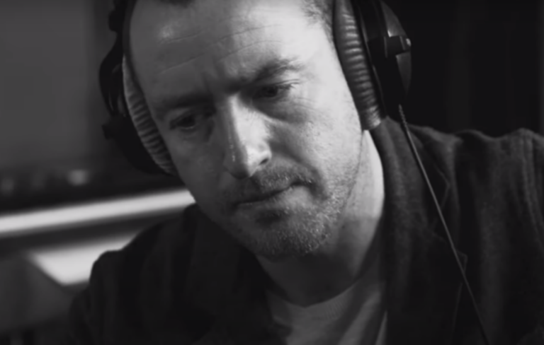 Stephen Fretwell performs 'Oval' in a studio, wearing headphones and singing into a microphone