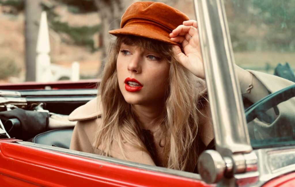 Taylor Swift poses in a Red car