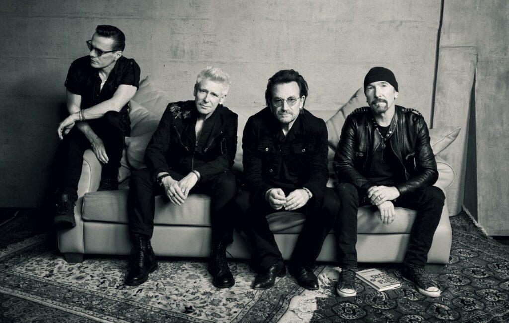 U2 pose on a sofa for promo shot