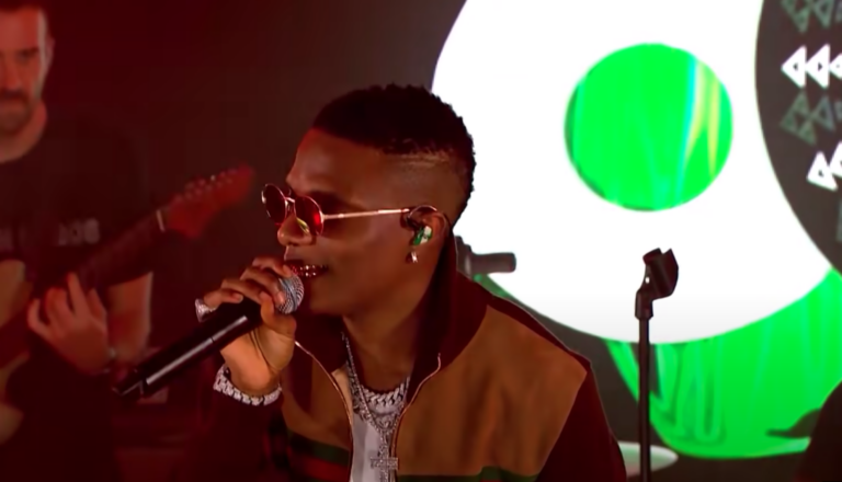 Wizkid performs live in Nigeria wear sunglasses and holding a microphone