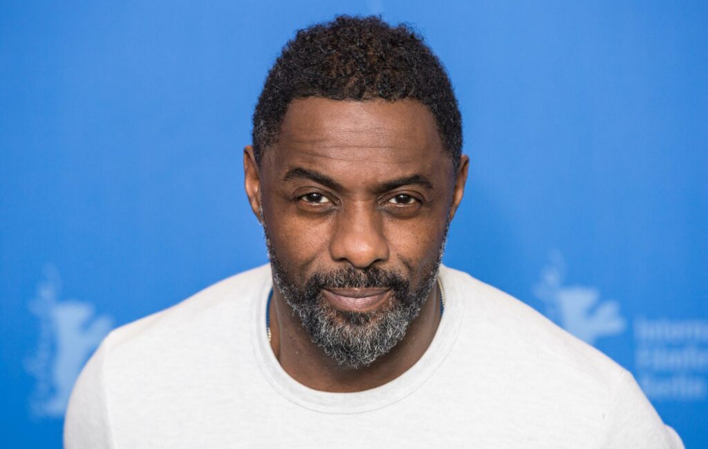 Idris Elba poses in a white shirt