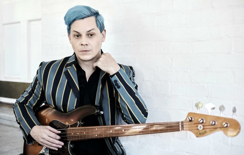 Jack White poses with a bass guitar