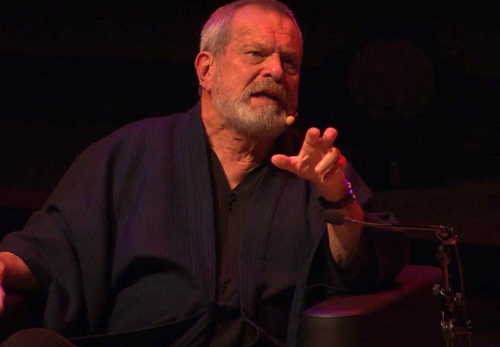 Terry talking into a headset in a darkened room
