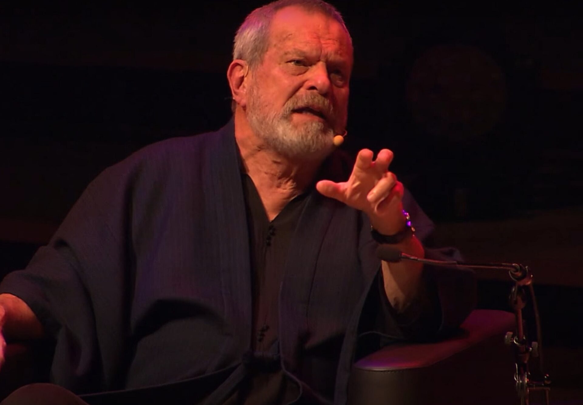 Terry talking into a headset in a darkened room
