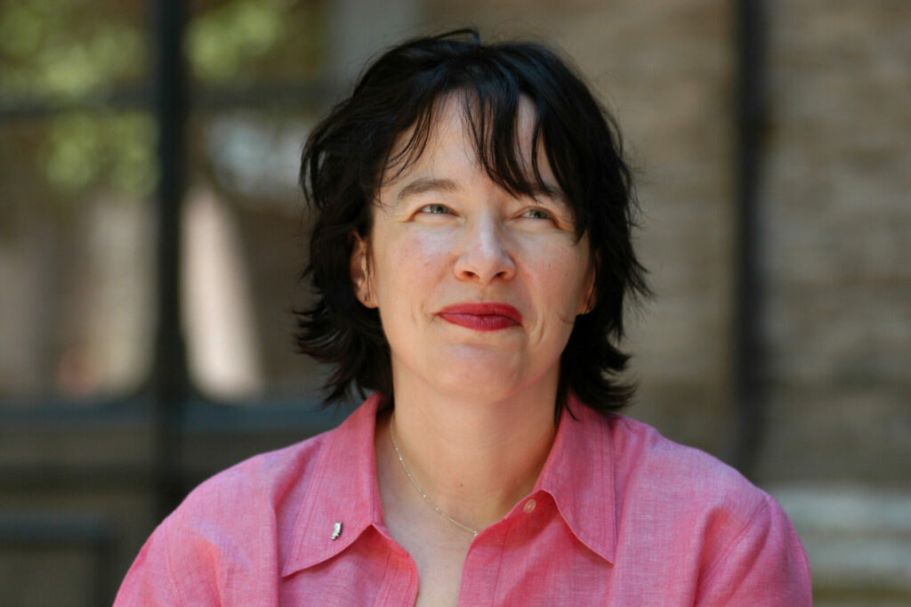 Alice Sebold wears a pink shirt and has short black hair in Rome