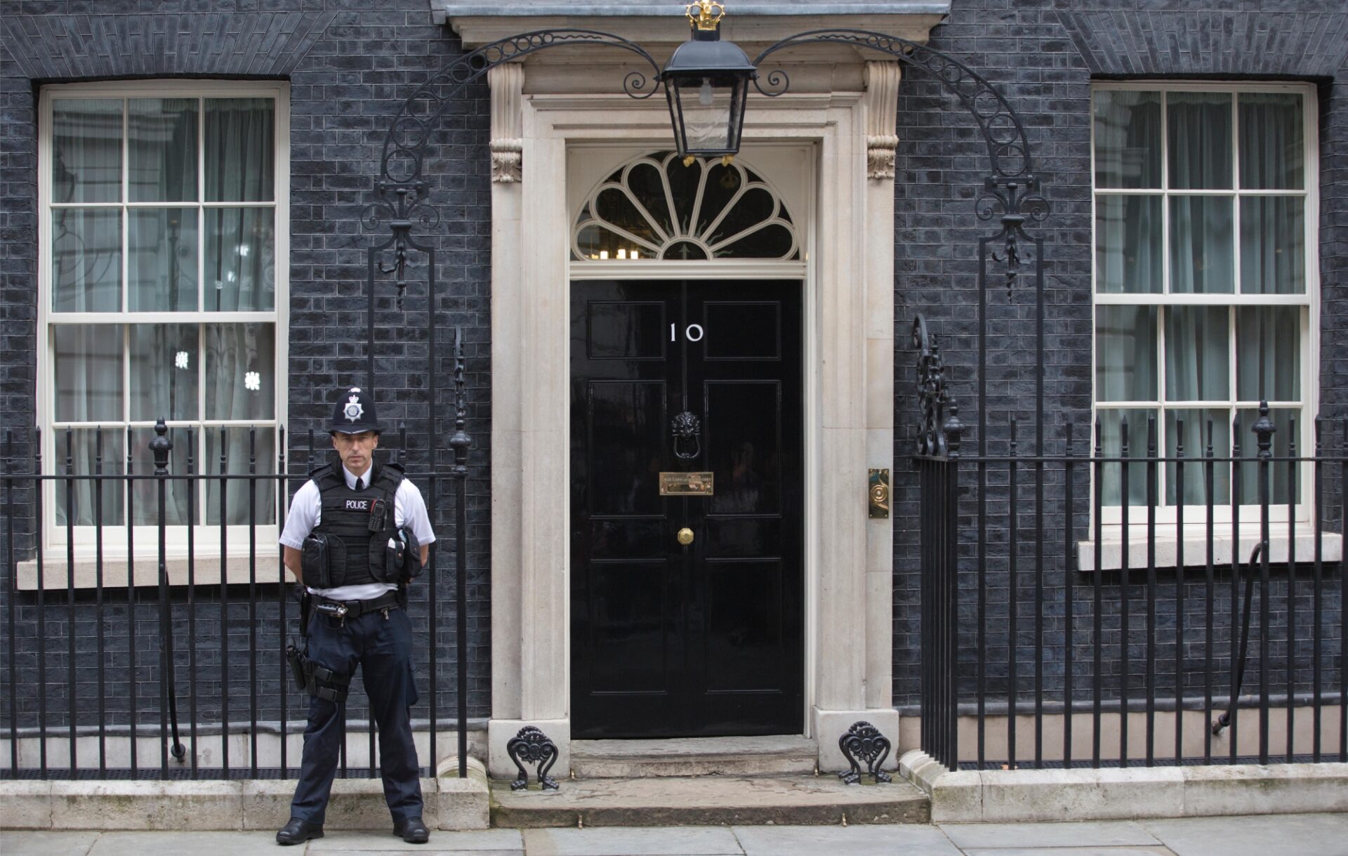 a police officer standing outside the front door of 10 Downing Street