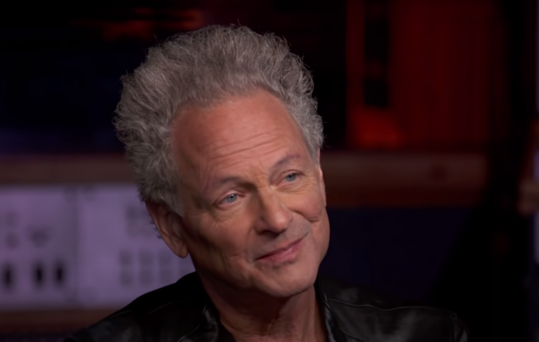 Lindsey Buckingham wears a black leather jacket in a TV interview with CBS