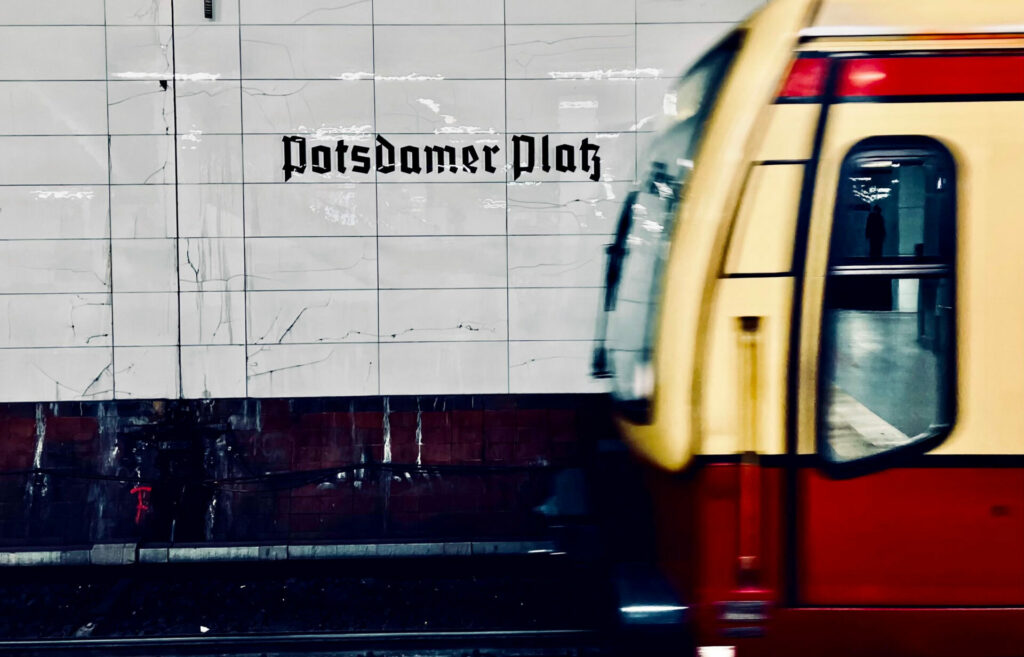 A picture of a train approaching a platform that reads 'Potsdamer Platz)