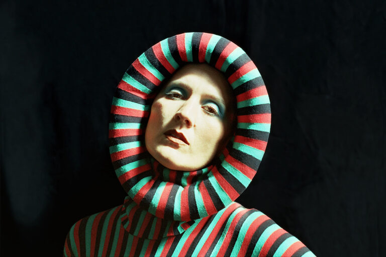 Cate Le Bon wears a red, black and green dress round her face