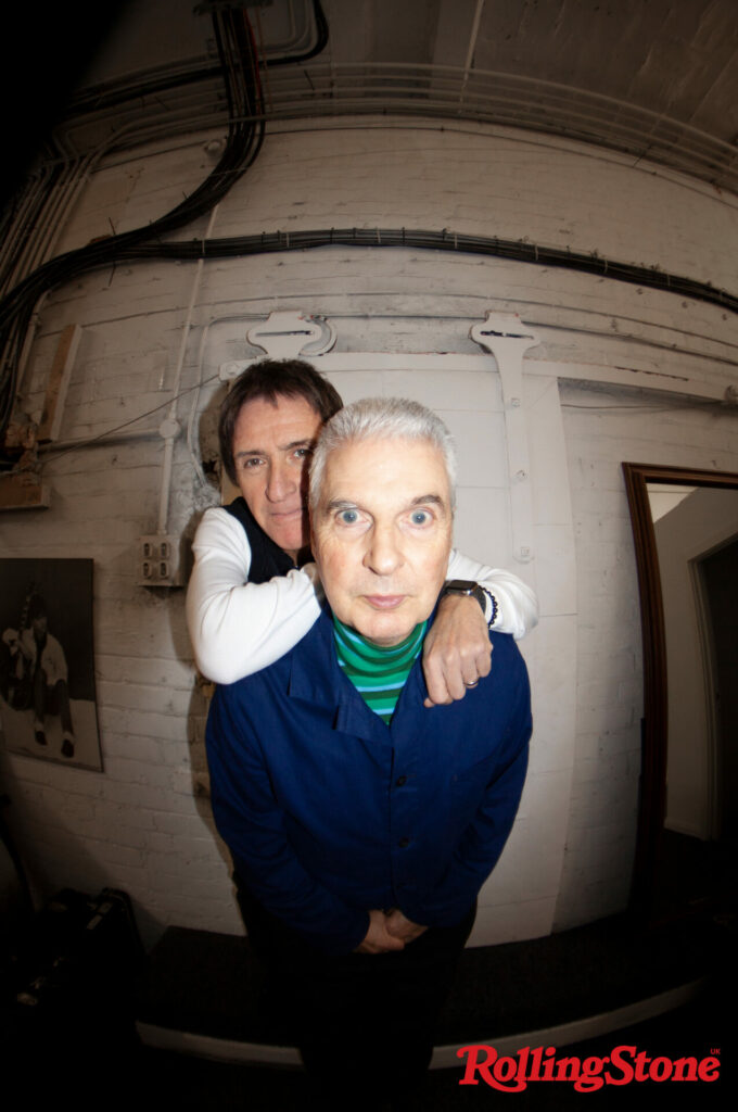 Johnny Marr stands behind Jon Savage in a fish eye lens photo
