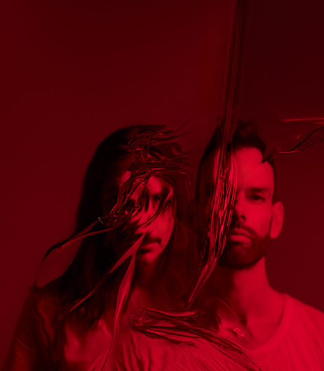 Placebo poses with distorted edits on front of their face in a red toned photo