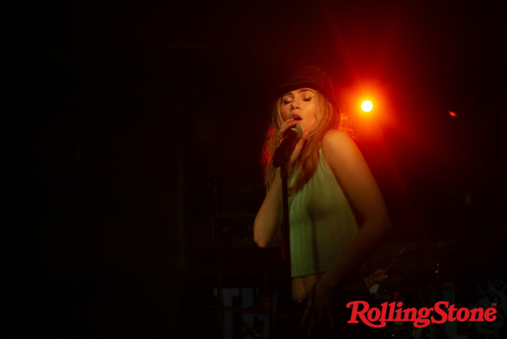 Suki Waterhouse performs live in a white vest and black hat