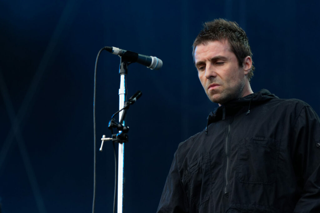 Liam Gallagher performs live wearing a black Parka jacket