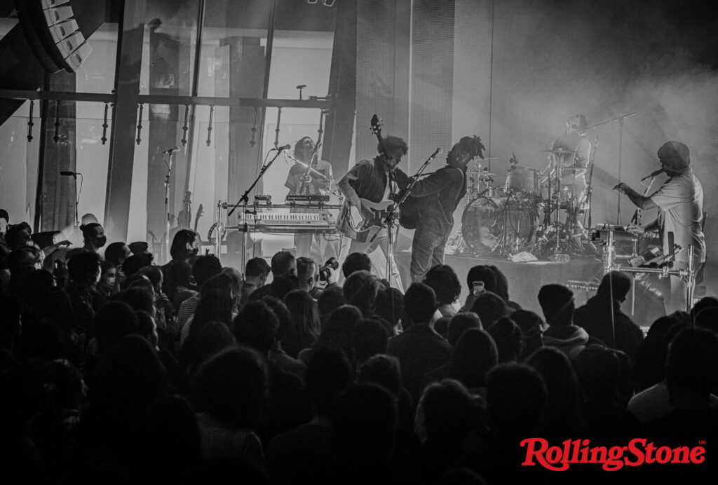 Metronomy perform to a live audience shot from a distance in black and white