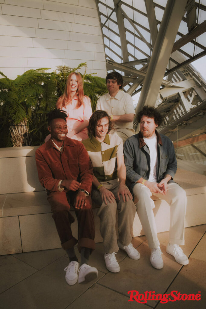 Metronomy sit together on a wall smiling and looking in different directions