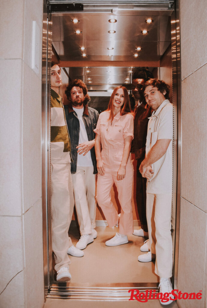 Metronomy stand together in a narrow hallway looking directly at the camera