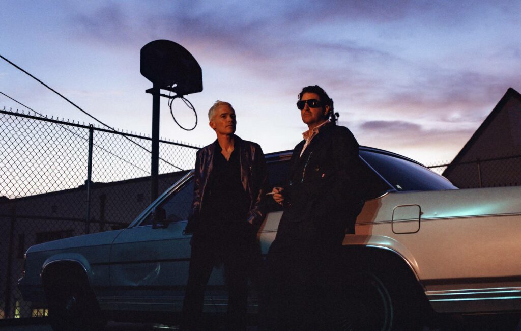 The Avalanches pose by a car at sunset
