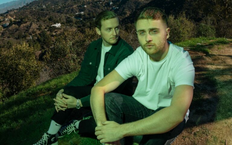 Disclosure sit next to each other on a hill in a press shot