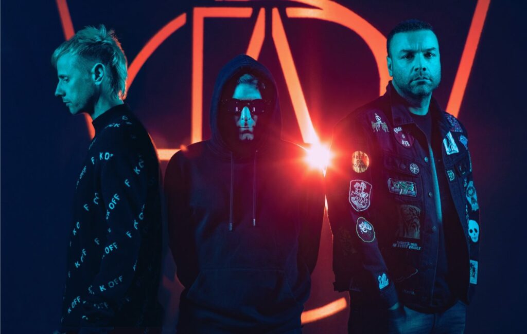 Muse stand in a line against a red outline and dark navy background in a blue-toned photo