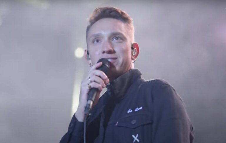 The xx's Oliver Sim performs live holding a microphone