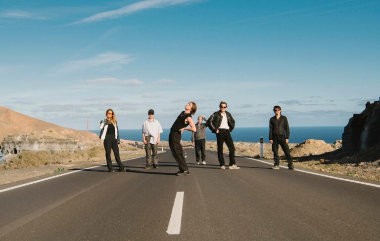 Sports Team pose in the middle of an open road by the sea