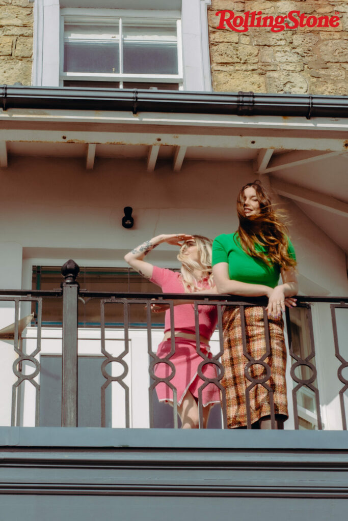 Wet Leg pose on a balcony as the wind blows their hair