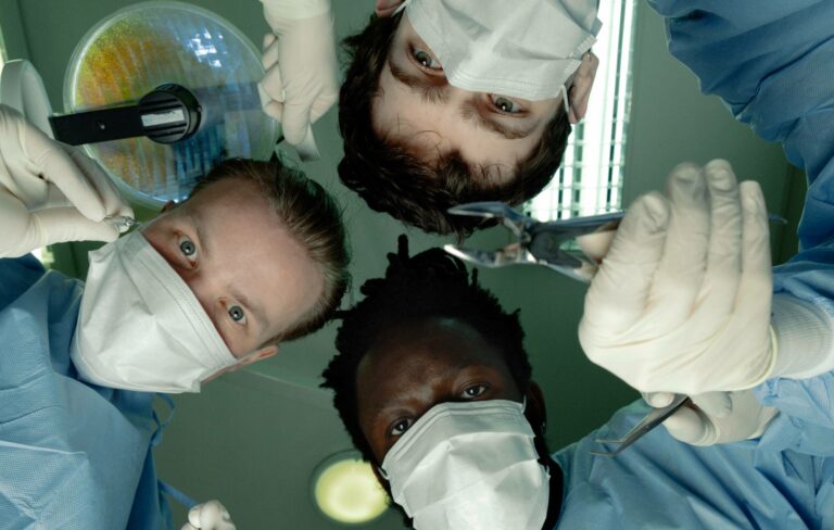 Black Midi posing for a photo as surgeons with gowns and medical masks