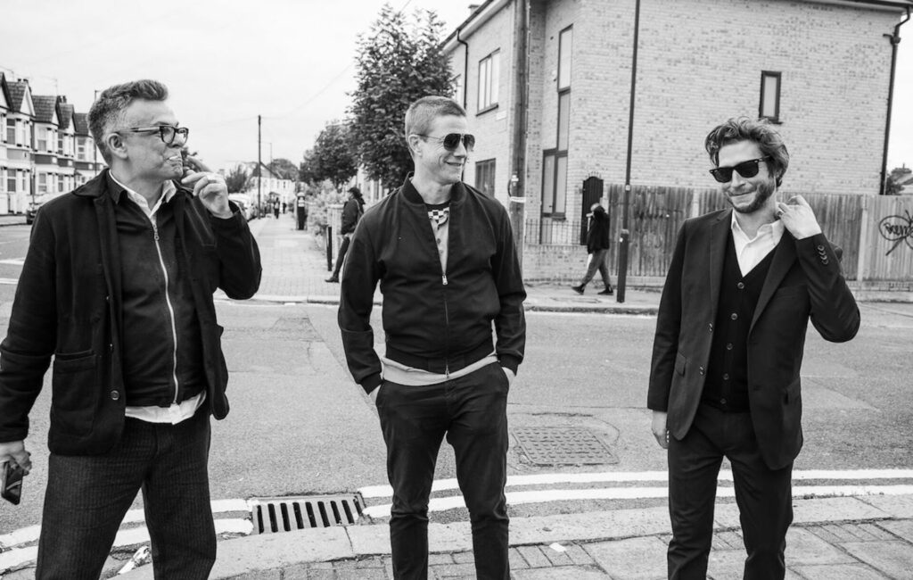 A black-and-white press photo of Interpol on a London street corner