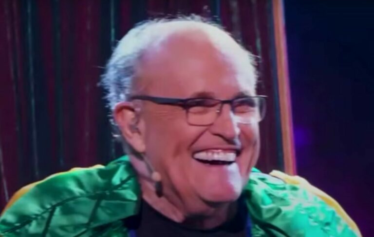 Rudy Giuliani wears glasses, a microphone and a green costume