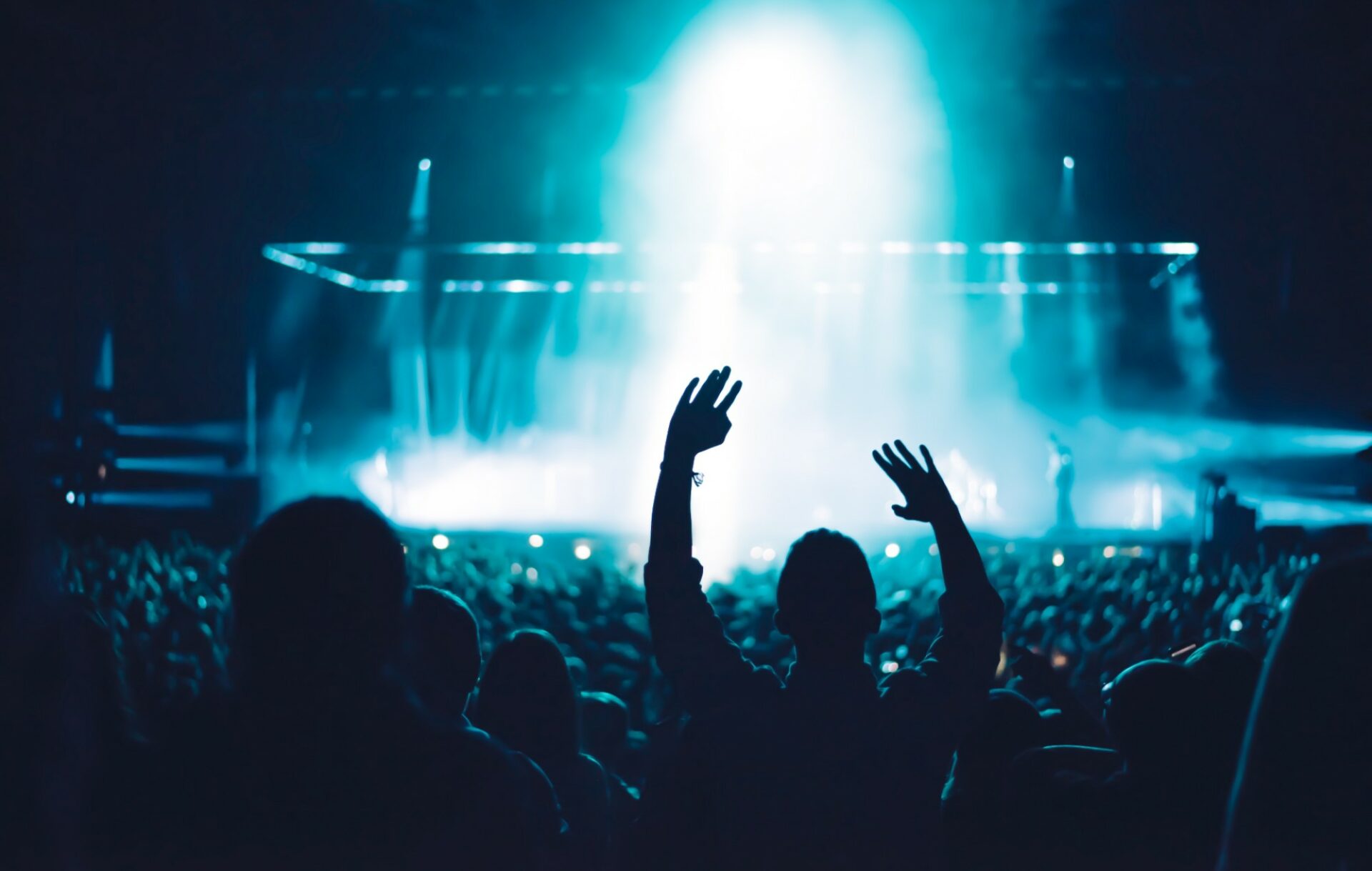 A crowd member puts their hands in the air at a live gig