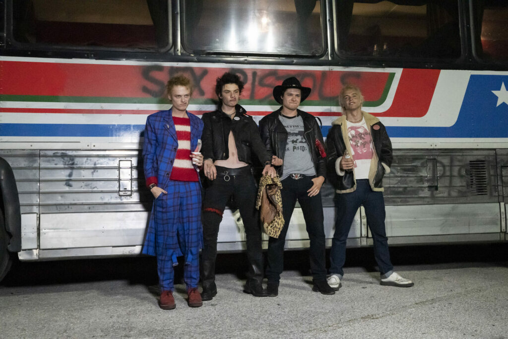 The cast of 'Pistol' dressed as the members of Sex Pistols stood against a bus