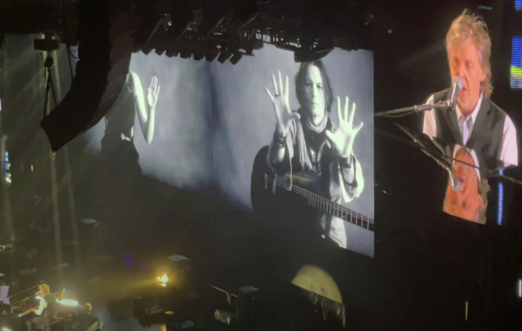 Screengrab of Paul McCartney playing 'My Valentine' in Seattle, with image of Johnny Depp in background