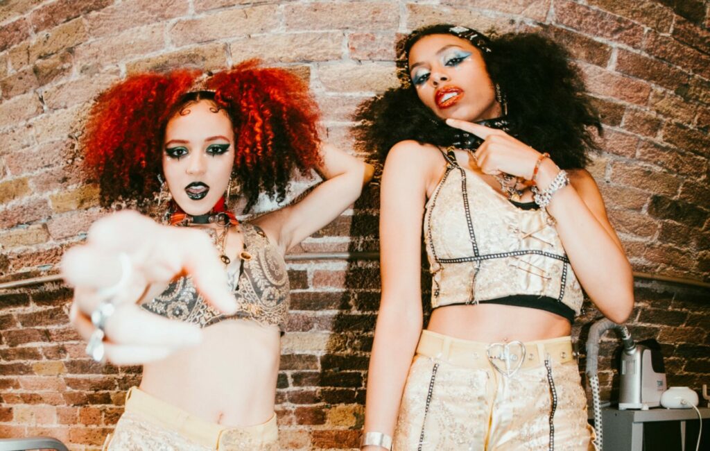 Nova Twins pose in shimmering gold crop tops and trousers