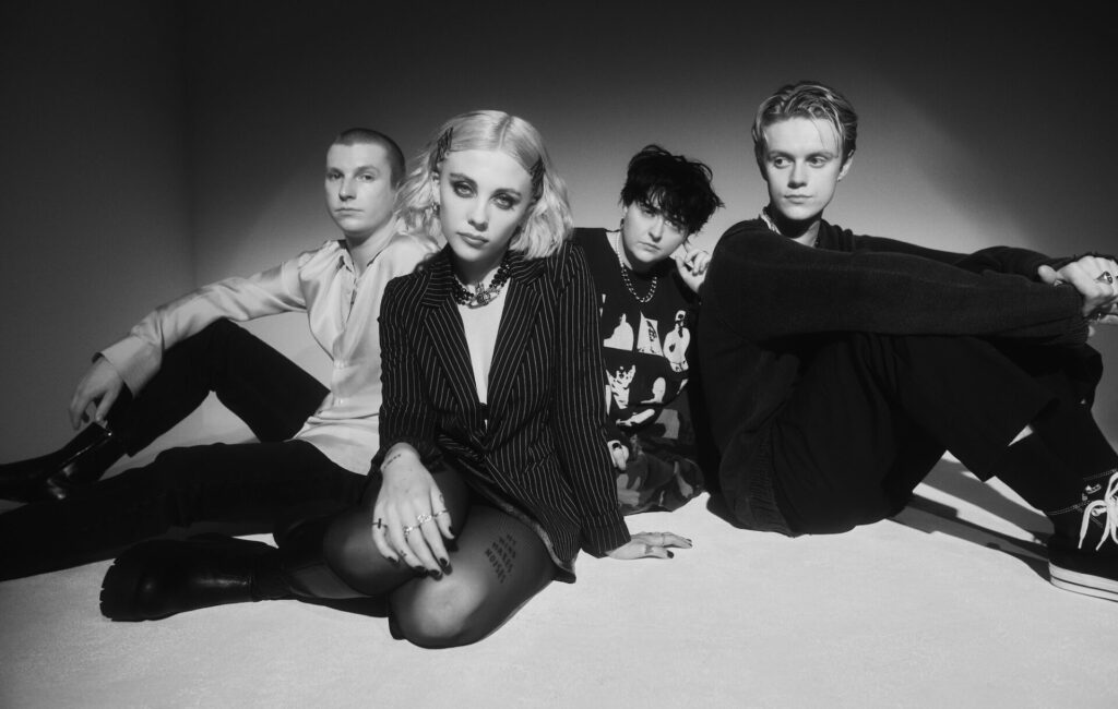 Pale Waves posing on the floor for a black-and-white press photo